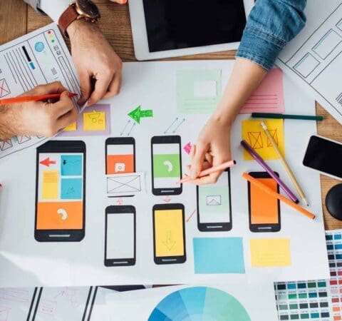 Top down view of creators in th eplanning stages of developing UX UI for digital app