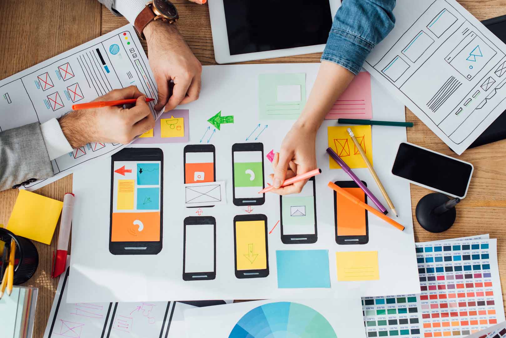 Top down view of creators in th eplanning stages of developing UX UI for digital app