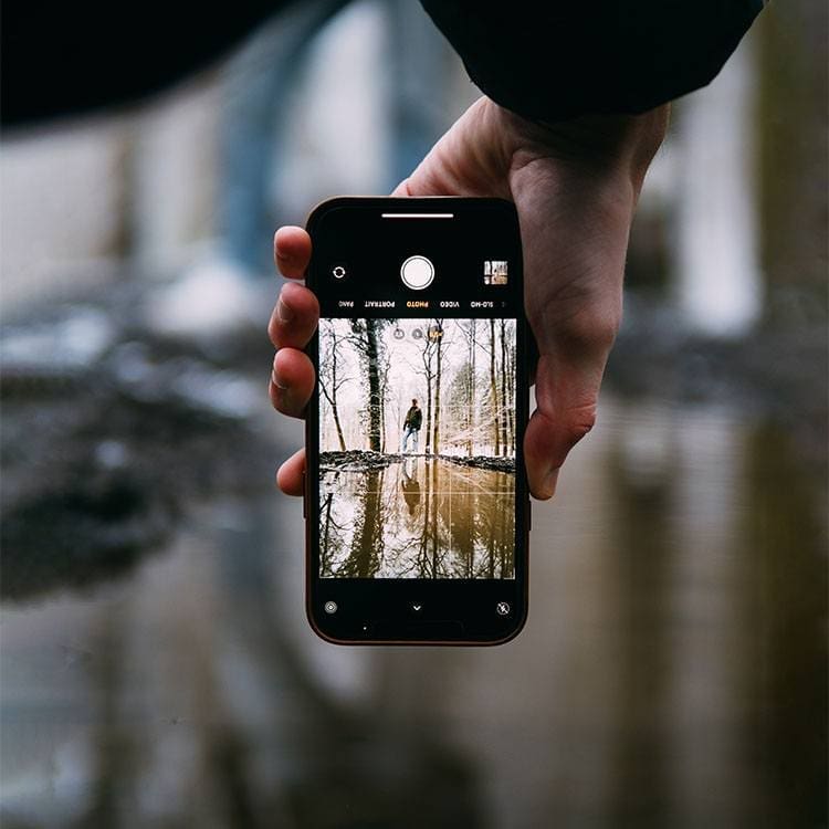 brecht-denil-wBH6wSm5KtU-unsplash a hand holding a cell phone