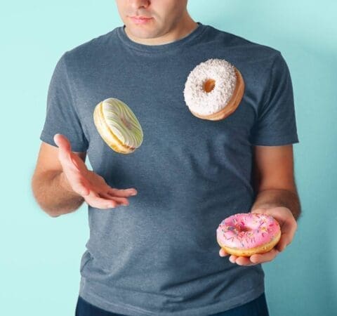 man juggling donuts