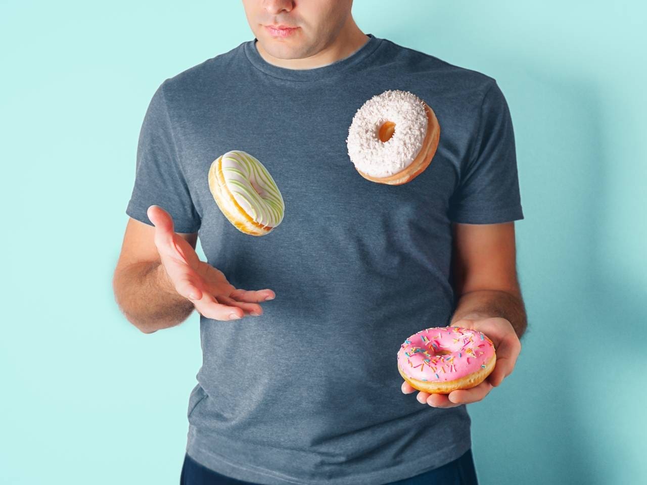 man juggling donuts