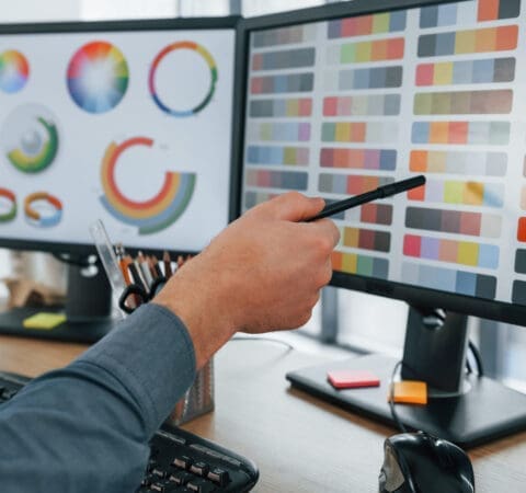 Using different colors. Male designer working in the office by using PC.