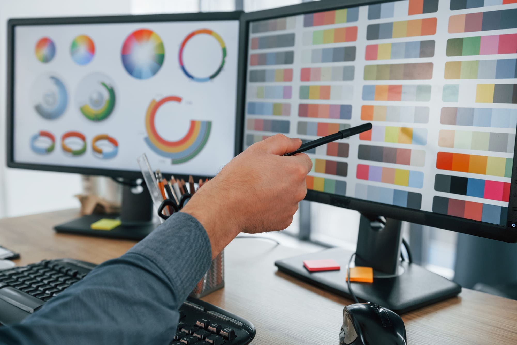 Using different colors. Male designer working in the office by using PC.
