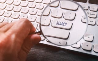 Word search on keyboard key seen through mangifying glass